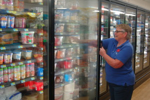 Manager Jackie Nunnenkamp stocks ice cream in the newly remodeled freezer section.