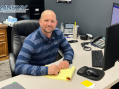 Photo of Jeremiah Duerksen sitting at his desk at Mainstay Communications